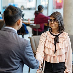 Student dressed in business attire shaking an employer's hand