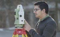 Aujas using surveying equipment mounted on a tripod