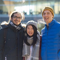 Three students dressed in winter clothing