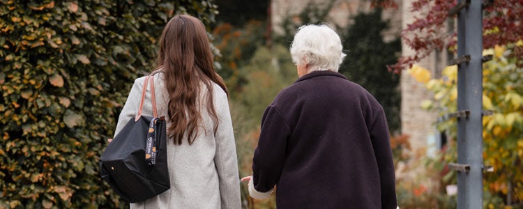 Katie and her grandmother walking together with their backs facing the camera