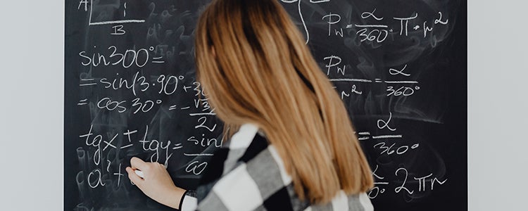 Student doing math on a blackboard.
