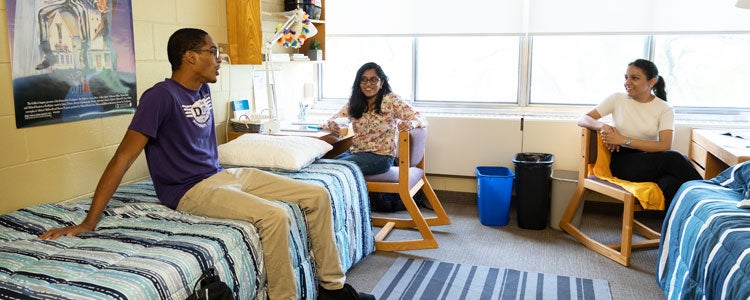 Three students hanging out in a residence room