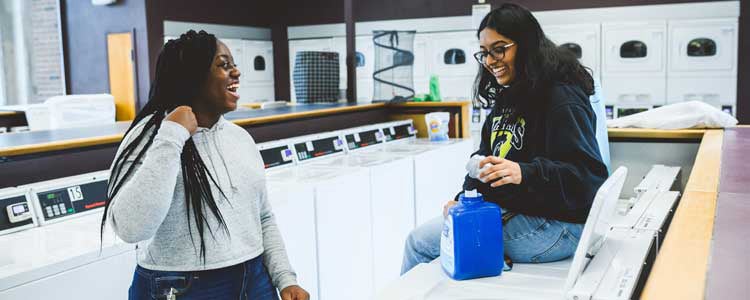 Two students doing laundry in residence together
