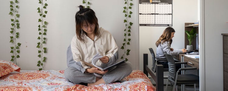 Two students sitting in their residence room studying