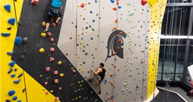 two students on rock climbing wall
