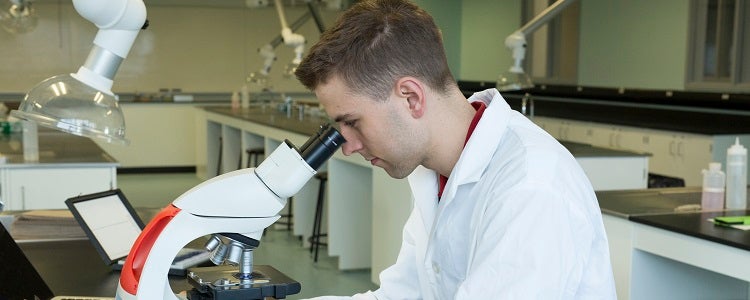 Waterloo Science student looking through a microscope