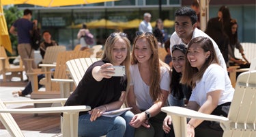 Students taking selfie sitting outside at the University of Waterloo