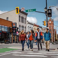 Waterloo students walking across the street sidewalk in uptown