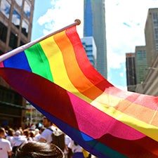 Pride flag being waved in a crowd of people in Waterloo