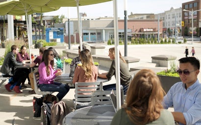 Groups of students sitting at tables outside 