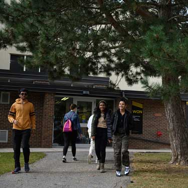 Students walking outside UWP, a shorter residence building.