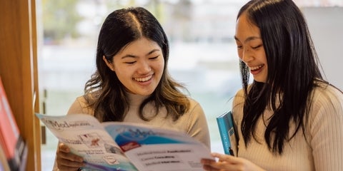 Two people looking at a booklet.
