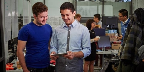 Two people looking at an iPad.