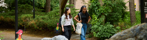 Two students walking outdoors on campus.