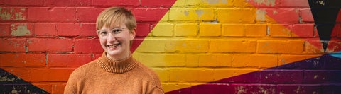 girl standing in front of colourful wall