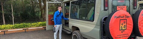 Sebastion standing in front of a Safari truck
