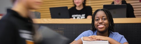 Student sitting at desk looking at camera