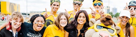Students in black and gold tshirts smile at the camera