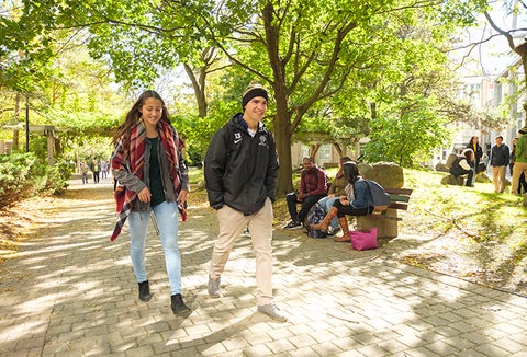 two students walking through campus on a fall day