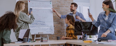 People taking pictures of a whiteboard.