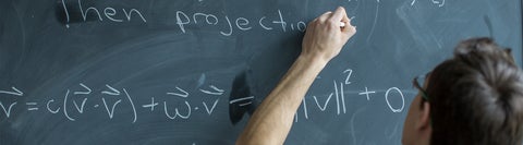 man writing on a chalkboard 