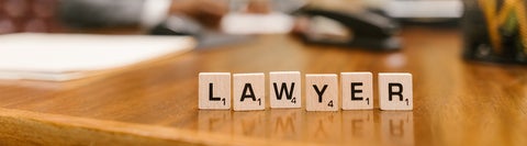 Wooden Scrable blocks spelling out the word "lawyer"