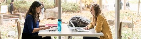 two students talking and studying in a bright space