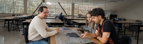 Waterloo co-op employer and co-op students sit at table reviewing plans