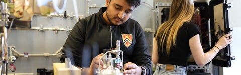 Two students building a project in an engineering workshop.
