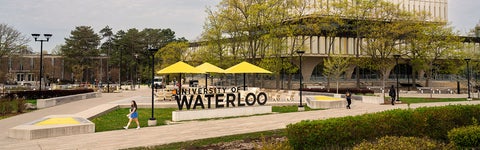 The Arts Quad at the University of Waterloo with a big Waterloo sign and yellow umbrellas