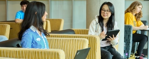 Students sitting chairs and looking at each other. 