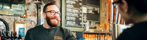 John, a Waterloo Recreation Business grad, talks with a customer at the Elora Brewing Company