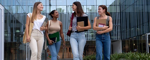 A group of four students walking out of a building together