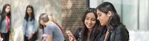 Student sitting together looking at a phone