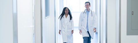 two people in lab coats walking