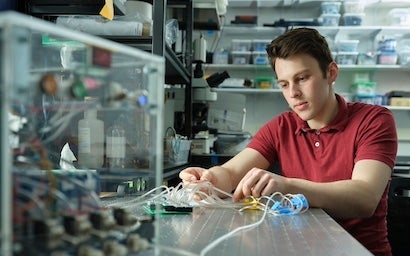 A student in a lab doing an experiment.