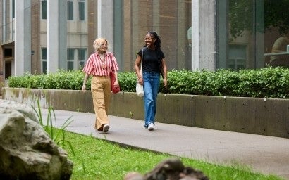 Two people walking outside and talking.