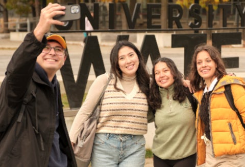 Students taking a selfie in front of the Waterloo sign