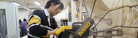 Victoria uses a bandsaw in the Environment Workshop