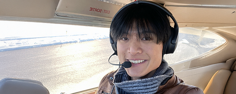 Daniel smiling in a plane with his headset on.