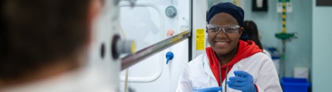 Biochemistry student holding a test tube in a lab.