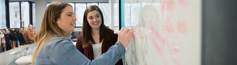 Students writing on a whiteboard