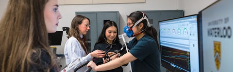 Professor and students assessing a student in a kinesiology lab