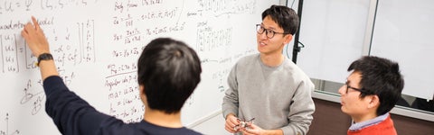 students writing on a whiteboard