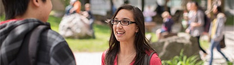 student talking to someone in a crowded outdoor space