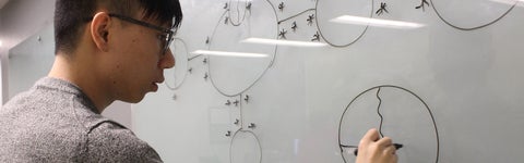 student writing on a whiteboard