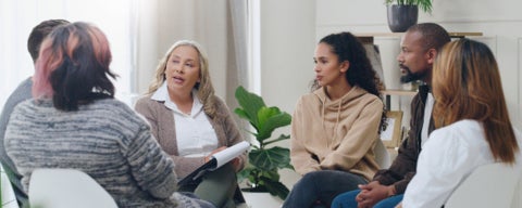 A group of people sitting in a circle conversing 