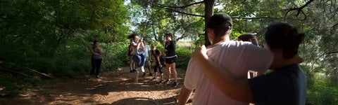 University of Waterloo recreation students on a rope swing in a forest