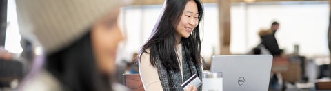 Student sitting at laptop with credit card in hand