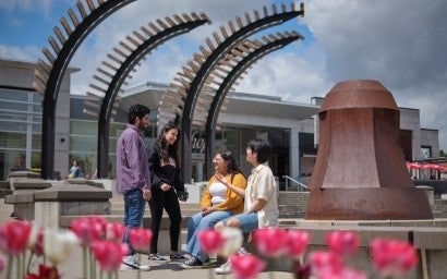 Four students having a conversation outside.